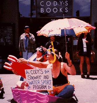 Carol Denney and Keith McHenry start a watersports program in front of Cody's to highlight their 'happy hose' anti-homeless policy. (1998)