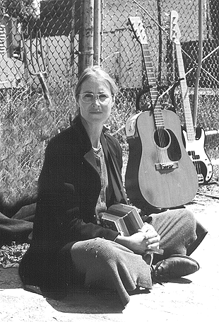 Carol Denney seated with implements of destruction.